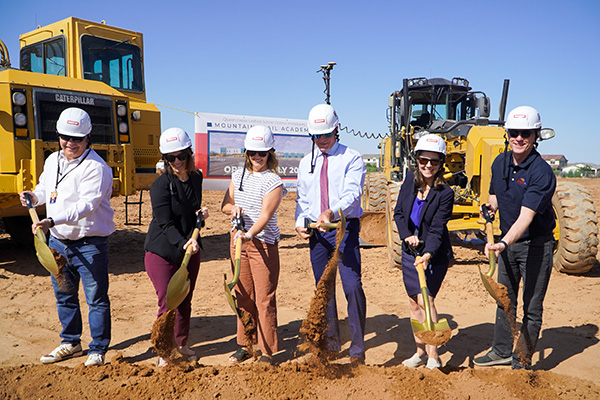 Men and women with shovels of dirt at groundbreaking ceremony